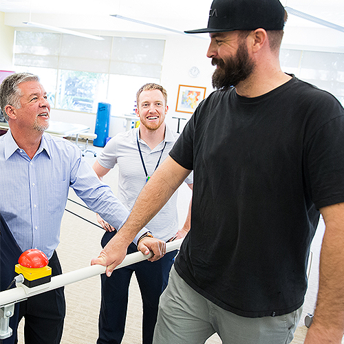 Dr. Mark Ashley talks to patient in during PT.